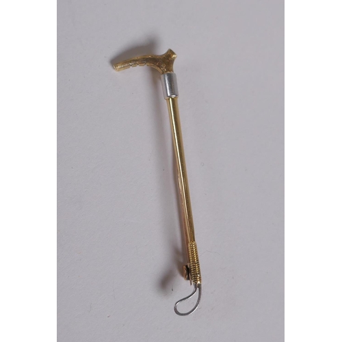 655 - A 15ct gold and white metal riding crop brooch, 3g gross, 5cm