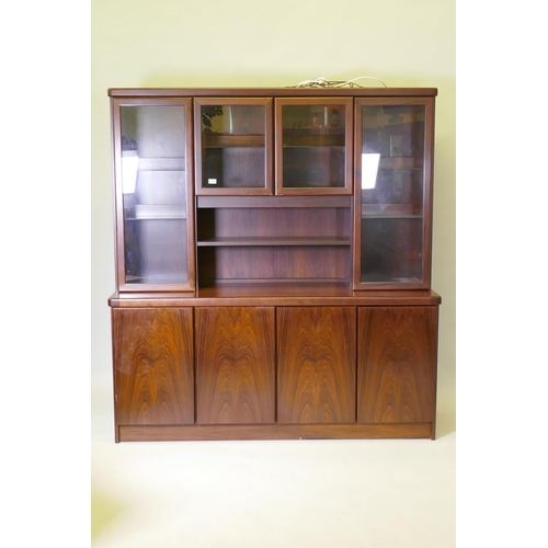 1009 - A Danish two section display cabinet, the upper section with four glazed doors, filled with glass sh... 