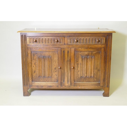 1014 - A mid century oak dresser with dome shaped upper rack on a base of two drawers over two cupboards, 1... 