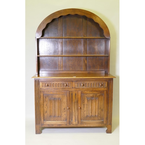 1014 - A mid century oak dresser with dome shaped upper rack on a base of two drawers over two cupboards, 1... 