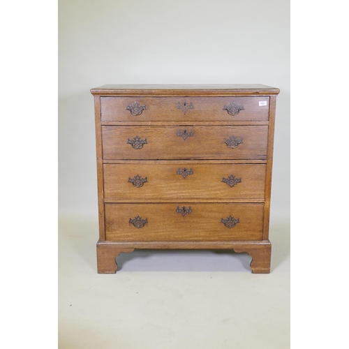 1027 - A Georgian oak garret chest in two sections, original brass fret handles and scratch moulded drawers... 