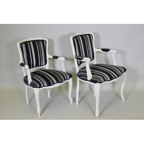 1028 - A pair of Louis XV style painted open arm chairs