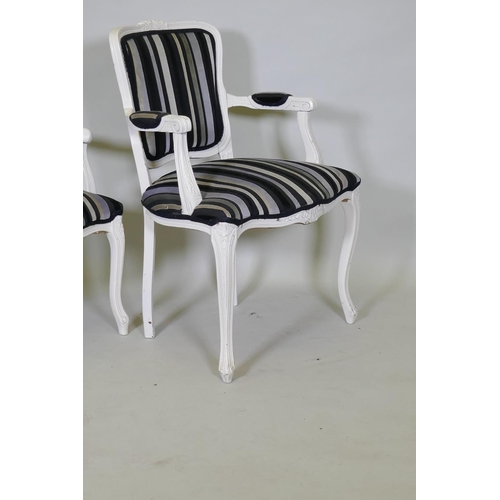 1028 - A pair of Louis XV style painted open arm chairs