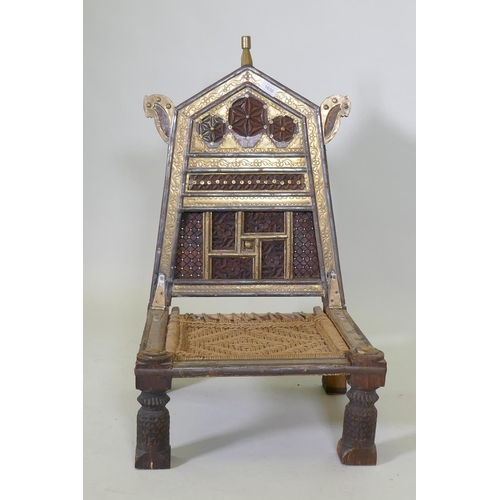 1030 - An antique Indian Pidha low chair with folding back, brass and iron mounts and webbed seat