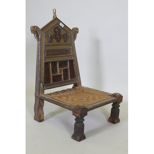 1030 - An antique Indian Pidha low chair with folding back, brass and iron mounts and webbed seat