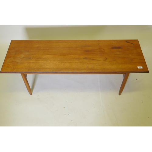 1042 - A mid century teak coffee table, raised on tapering supports united by shaped end stretchers, 40 x 1... 