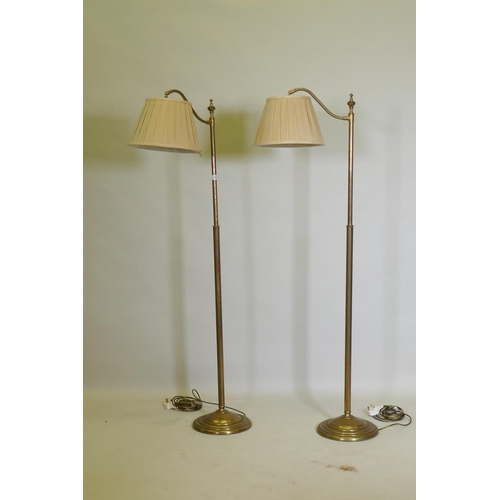 1054 - A pair of brass floor lamps with directional function, now AF, 146cm high