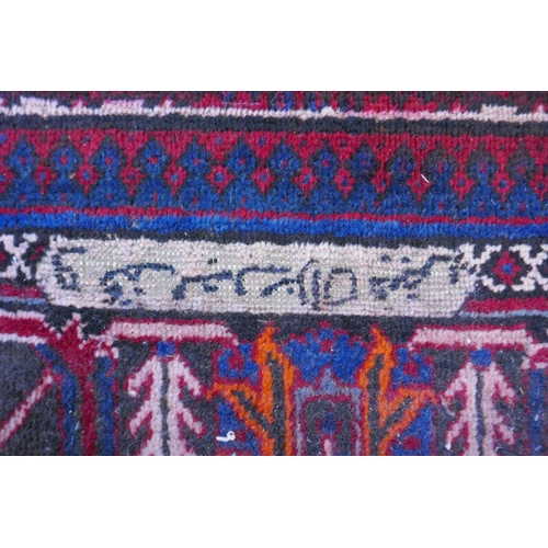 1060 - A claret and blue ground Persian Joshaghan tribal carpet with traditional medallion design, signed, ... 