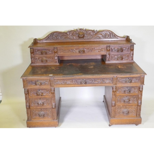 1067 - A Victorian oak nine drawer pedestal desk with mask carved handles, inset leather top and upper sect... 