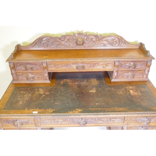 1067 - A Victorian oak nine drawer pedestal desk with mask carved handles, inset leather top and upper sect... 