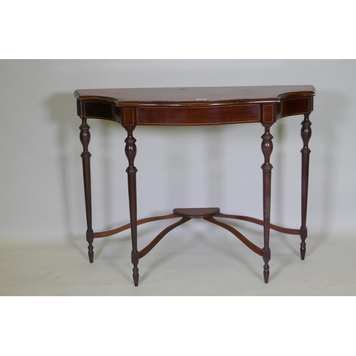 1069 - An inlaid mahogany console table with shaped top and four turned supports united by a shaped stretch... 