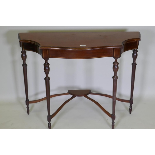 1069 - An inlaid mahogany console table with shaped top and four turned supports united by a shaped stretch... 