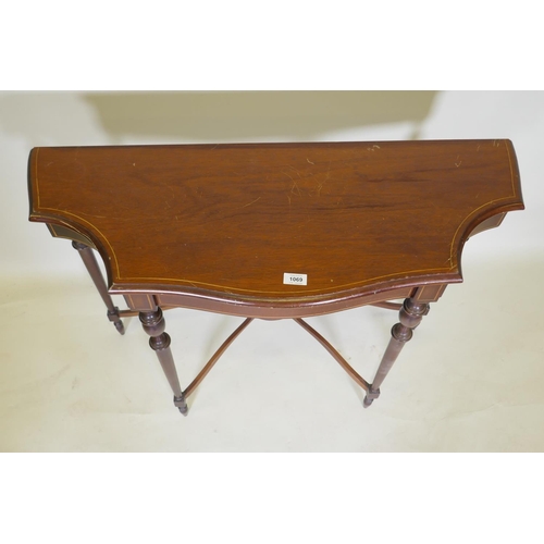 1069 - An inlaid mahogany console table with shaped top and four turned supports united by a shaped stretch... 