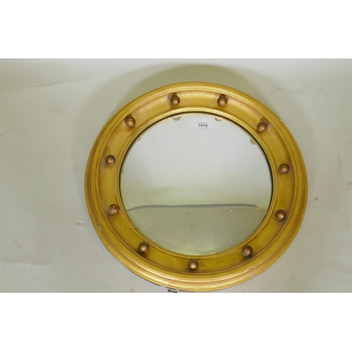 1078 - A C19th Regency style giltwood circular wall mirror with convex glass, 50cm diameter