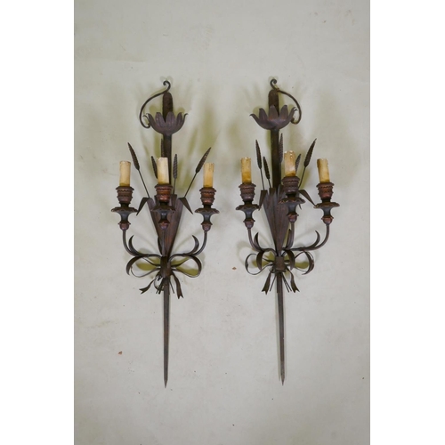 1081 - A pair of wrought iron and painted wood three branch sconces in the form of wheat ears and a sword h... 