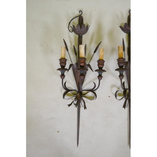 1081 - A pair of wrought iron and painted wood three branch sconces in the form of wheat ears and a sword h... 