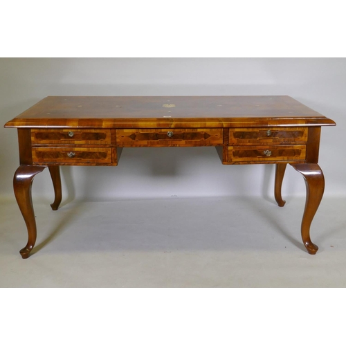 1086 - A continental walnut and marquetry inlaid bureau plat, with five drawers, raised on cabriole support... 