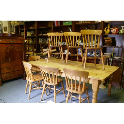 1090 - A pine farmhouse table, raised on turned supports, 213 x 120cm, and seven lathe back Windsor chairs