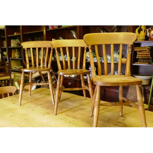 1090 - A pine farmhouse table, raised on turned supports, 213 x 120cm, and seven lathe back Windsor chairs