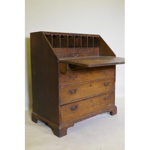 1118 - A Georgian oak fall front bureau with fitted interior over three drawers, raised on bracket supports