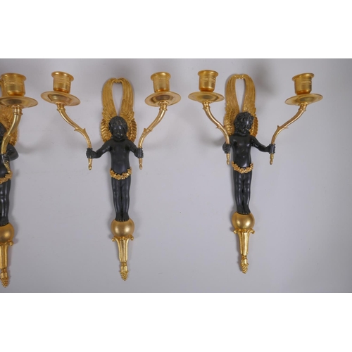 114 - Two pairs of ormolu and bronze two branch candle sconces in the form of winged putti, 34cm high