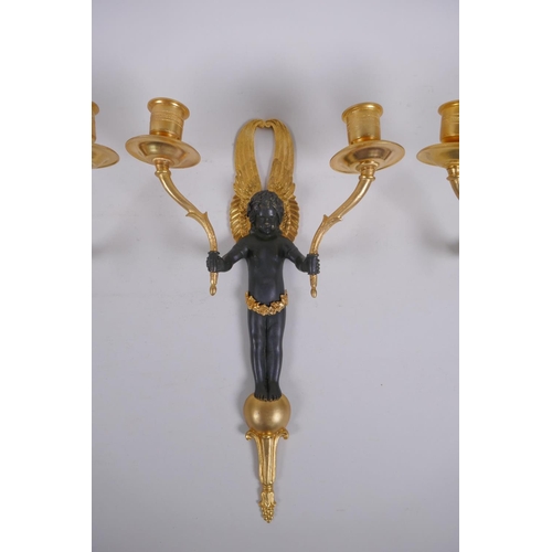 114 - Two pairs of ormolu and bronze two branch candle sconces in the form of winged putti, 34cm high