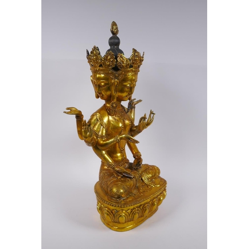 122 - A large Sino Tibetan gilt bronze figure of a deity with many arms and faces, impressed double vajra ... 