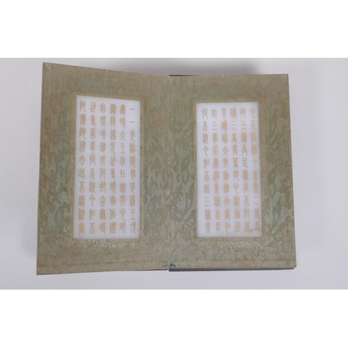 123 - A Chinese fabric and wood bound book containing white jade tablets with chased and gilt character in... 