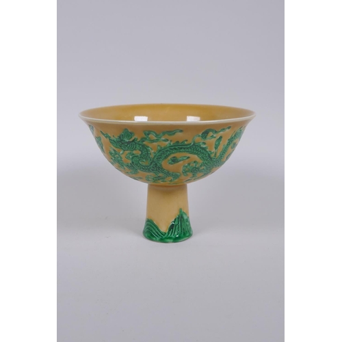 135 - A Chinese yellow ground porcelain stem bowl with raised green enamelled dragon decoration, Xuande 6 ... 