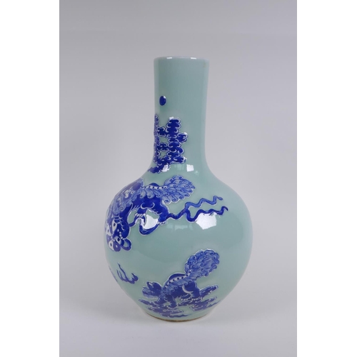 143 - A Chinese celadon ground porcelain bottle vase with raised blue and white kylin decoration, 35cm hig... 