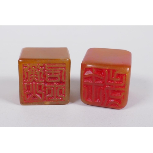 148 - A Chinese amber soapstone seal with Buddha head decoration, and another similar, 3 x 3cm