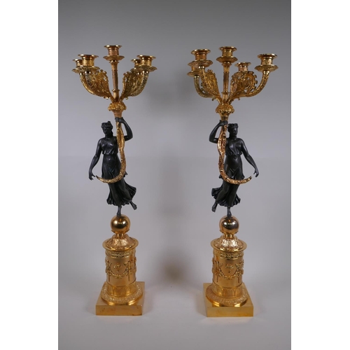 164 - A pair of bronze and ormolu four branch candelabra in the form of classical women, 71cm high
