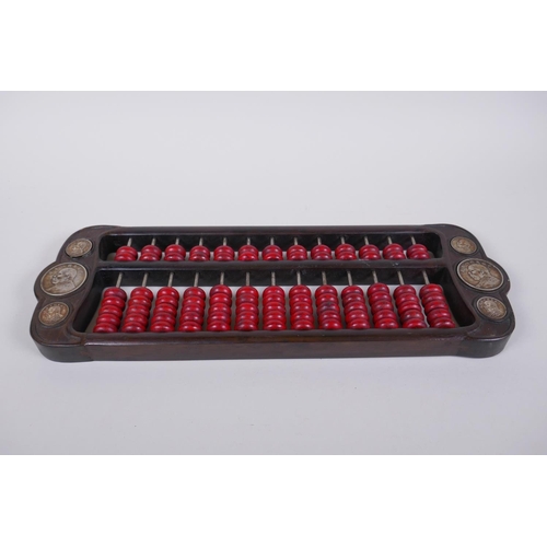 173 - A Chinese hardwood and red stone abacus set with decorative white metal coins, 42 x 14cm