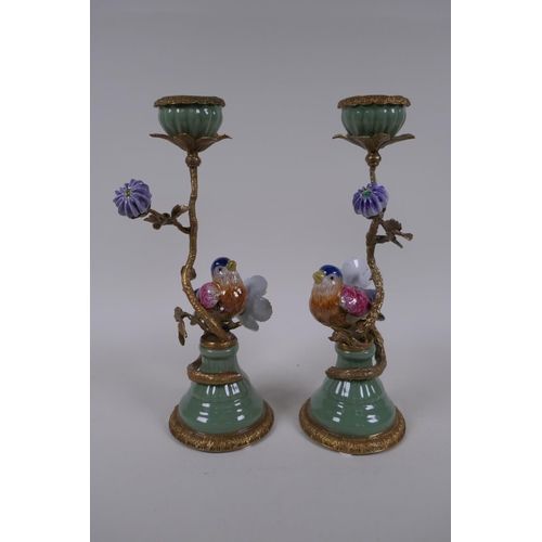 189 - A pair of polychrome porcelain and gilt metal candlesticks decorated with birds and flowers, 29cm hi... 