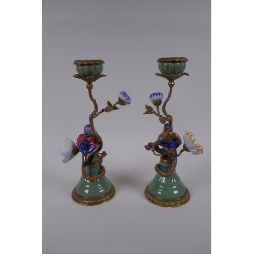 189 - A pair of polychrome porcelain and gilt metal candlesticks decorated with birds and flowers, 29cm hi... 