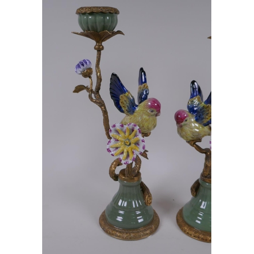 201 - A pair of polychrome porcelain and gilt metal candlesticks decorated with birds and flowers, 32cm hi... 