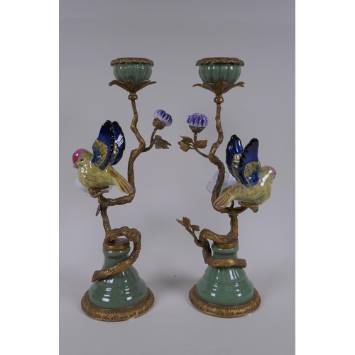 201 - A pair of polychrome porcelain and gilt metal candlesticks decorated with birds and flowers, 32cm hi... 