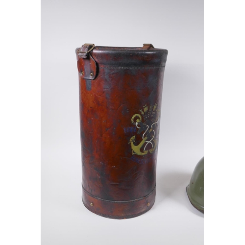 242 - A vintage leather shell case decorated with a later applied armorial crest, and a steel military hel... 