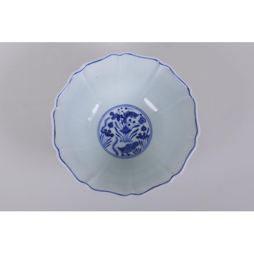 250 - A blue and white porcelain steep sided bowl with lobed rim, decorated with carp in a lotus pond, Chi... 