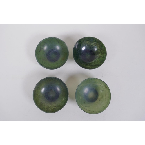 266 - Four Chinese spinach jade bowls, AF repairs, 7cm diameter