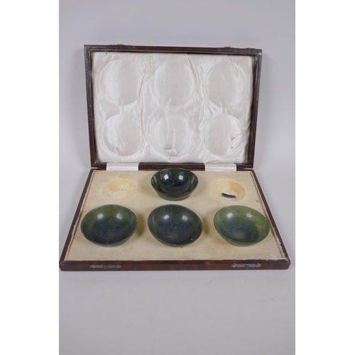 266 - Four Chinese spinach jade bowls, AF repairs, 7cm diameter