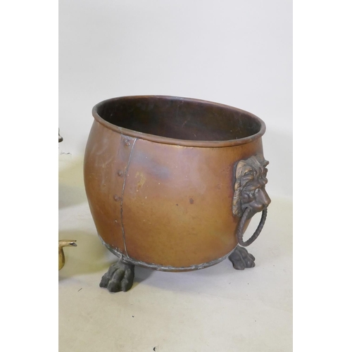 287 - An antique riveted copper coal scuttle with brass lion mask handles and paw feet, together with a br... 