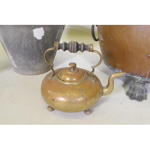 287 - An antique riveted copper coal scuttle with brass lion mask handles and paw feet, together with a br... 