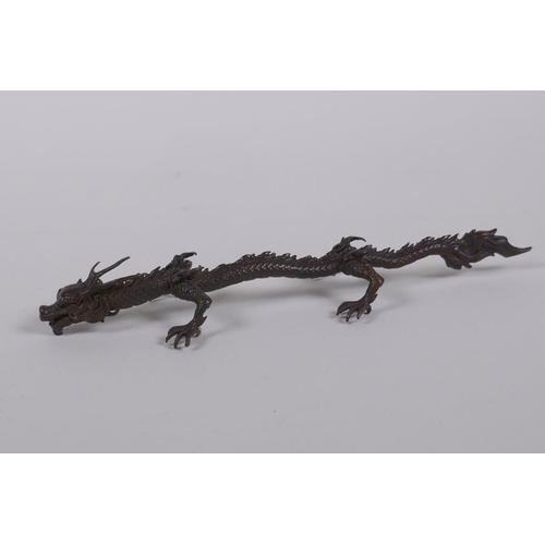 50 - An oriental bronze figure of a five toed dragon, indistinct mark to base, 15cm long