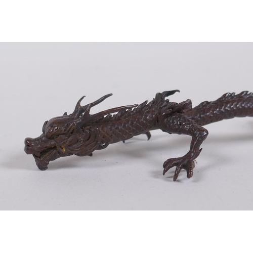 50 - An oriental bronze figure of a five toed dragon, indistinct mark to base, 15cm long