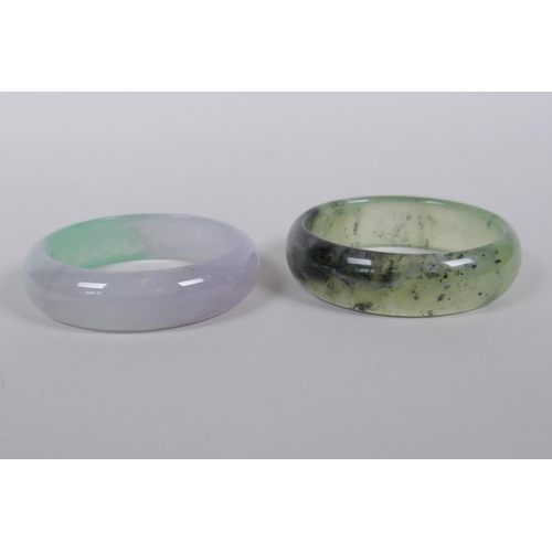 605 - A bi-colour jade bangle, and another, 7cm diameter