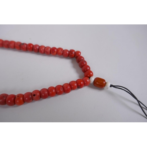 610 - A string of bone mala beads, and a string of coral mala beads, longest 108cm