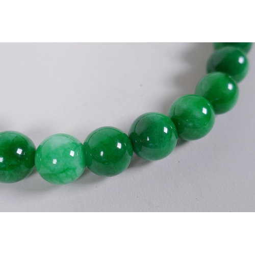 620 - A Chinese apple green hardstone bead necklace, 44cm long