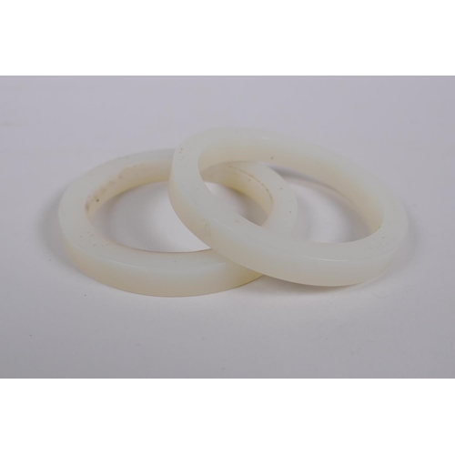 624 - Two white hardstone bangles, 7cm diameter