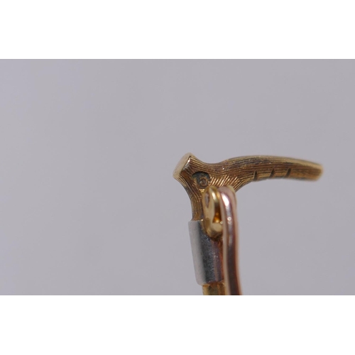 655 - A 15ct gold and white metal riding crop brooch, 3g gross, 5cm